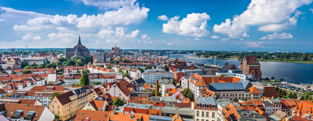 Blick über die Altstadt von Rostock zur Warnow, im Vordergrund rote Ziegeldächer